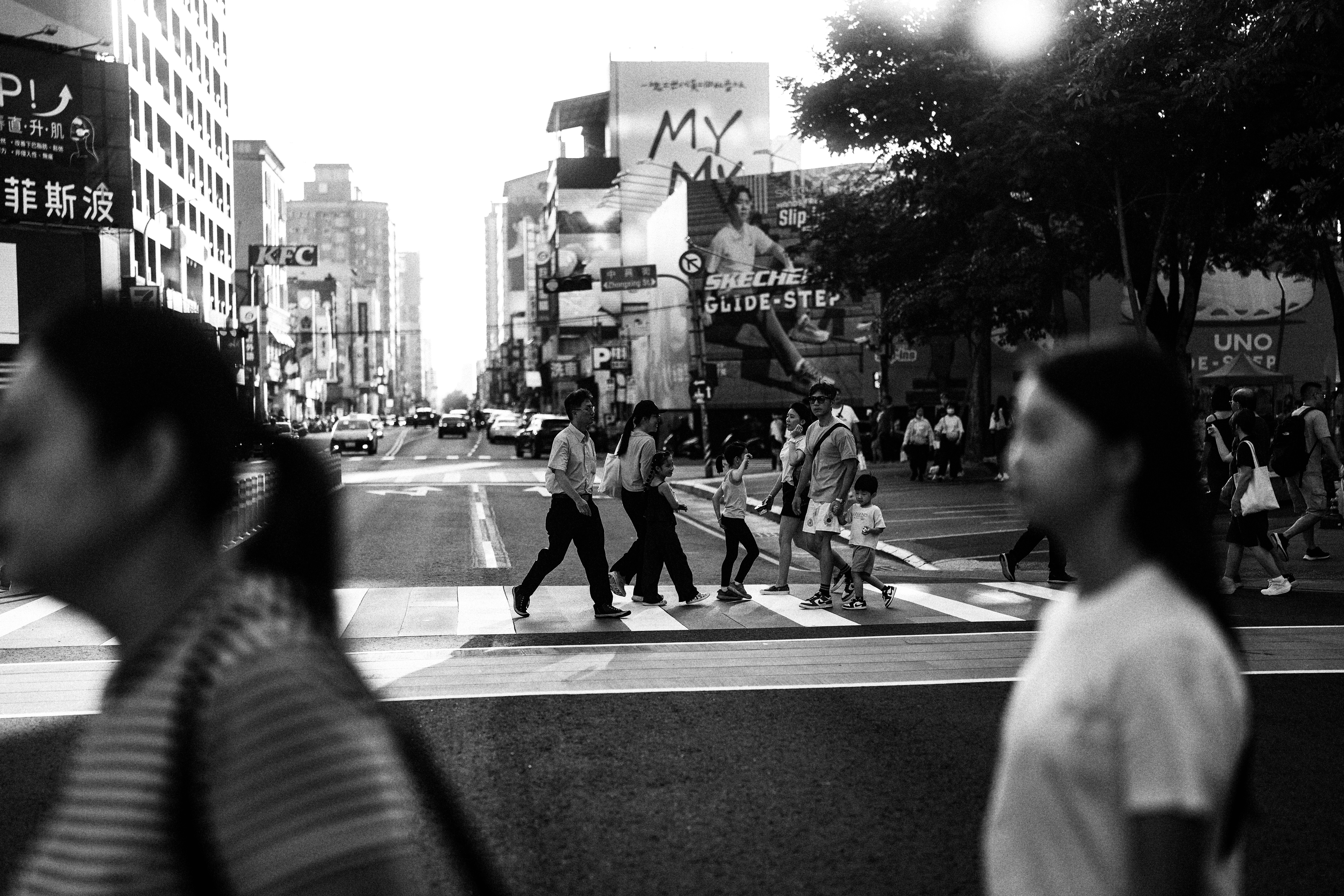 Pedestrians crossing broad white stripes on a city street