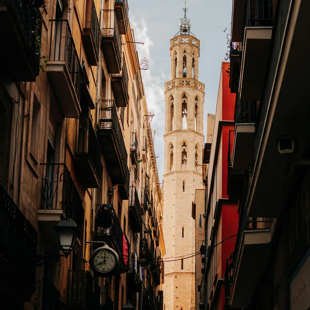 A stone tower framed by the closely spaced buildings of a narrow old street