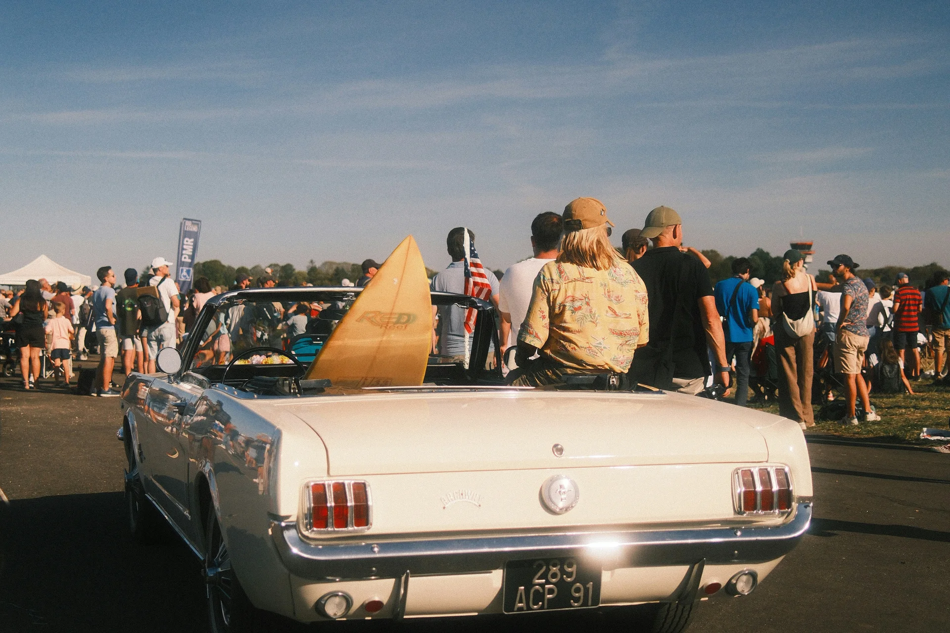 Friends riding in the back of a white convertible