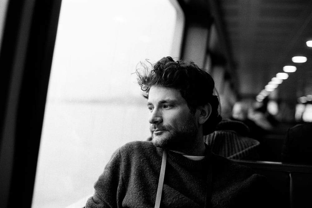 Black and white portrait of a man beside a train window
