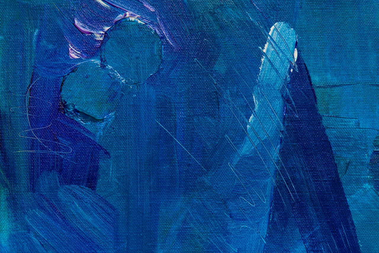 Overlapping brushstrokes in deep and pale blue paint
