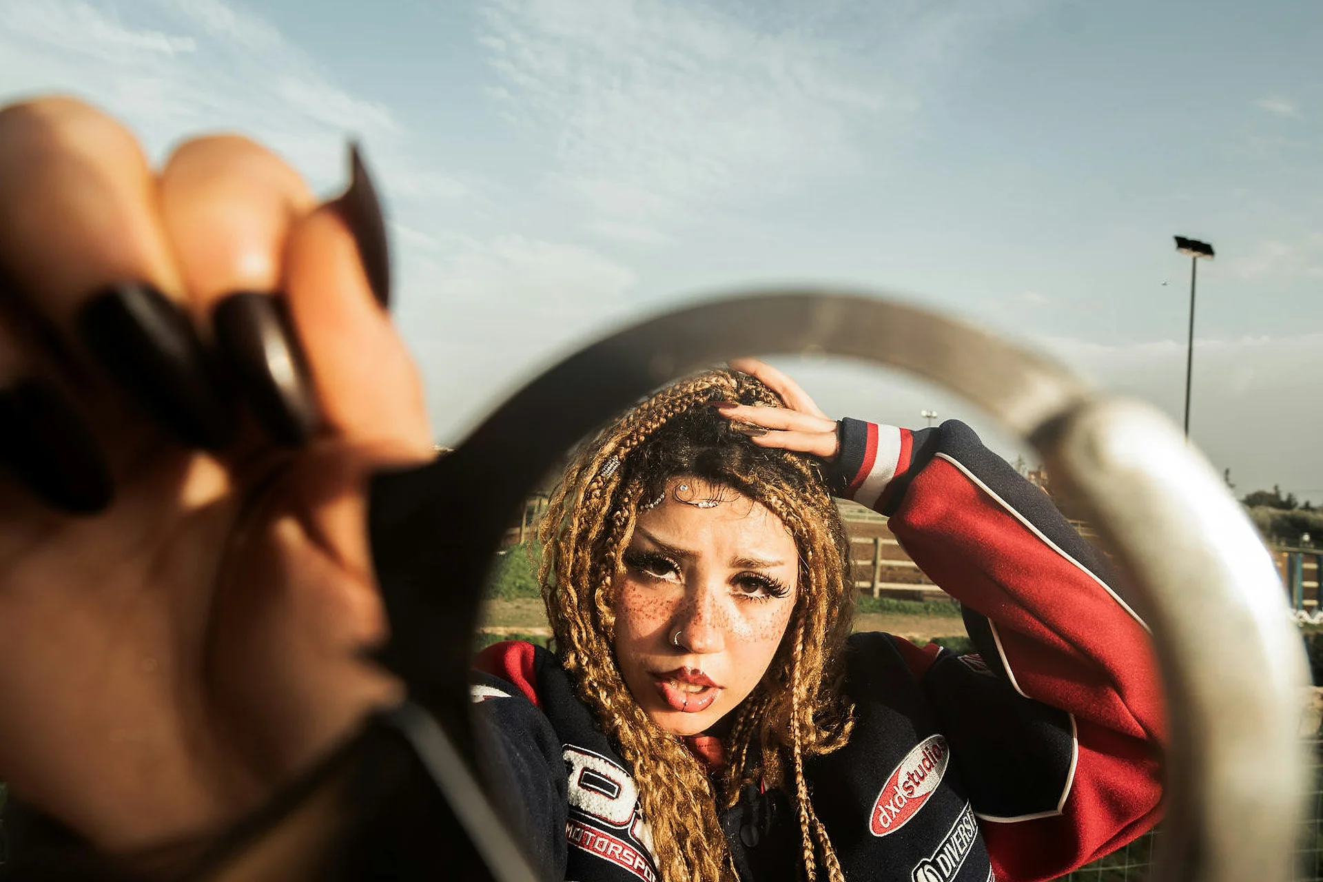 A woman reflected in a round mirror held toward the camera