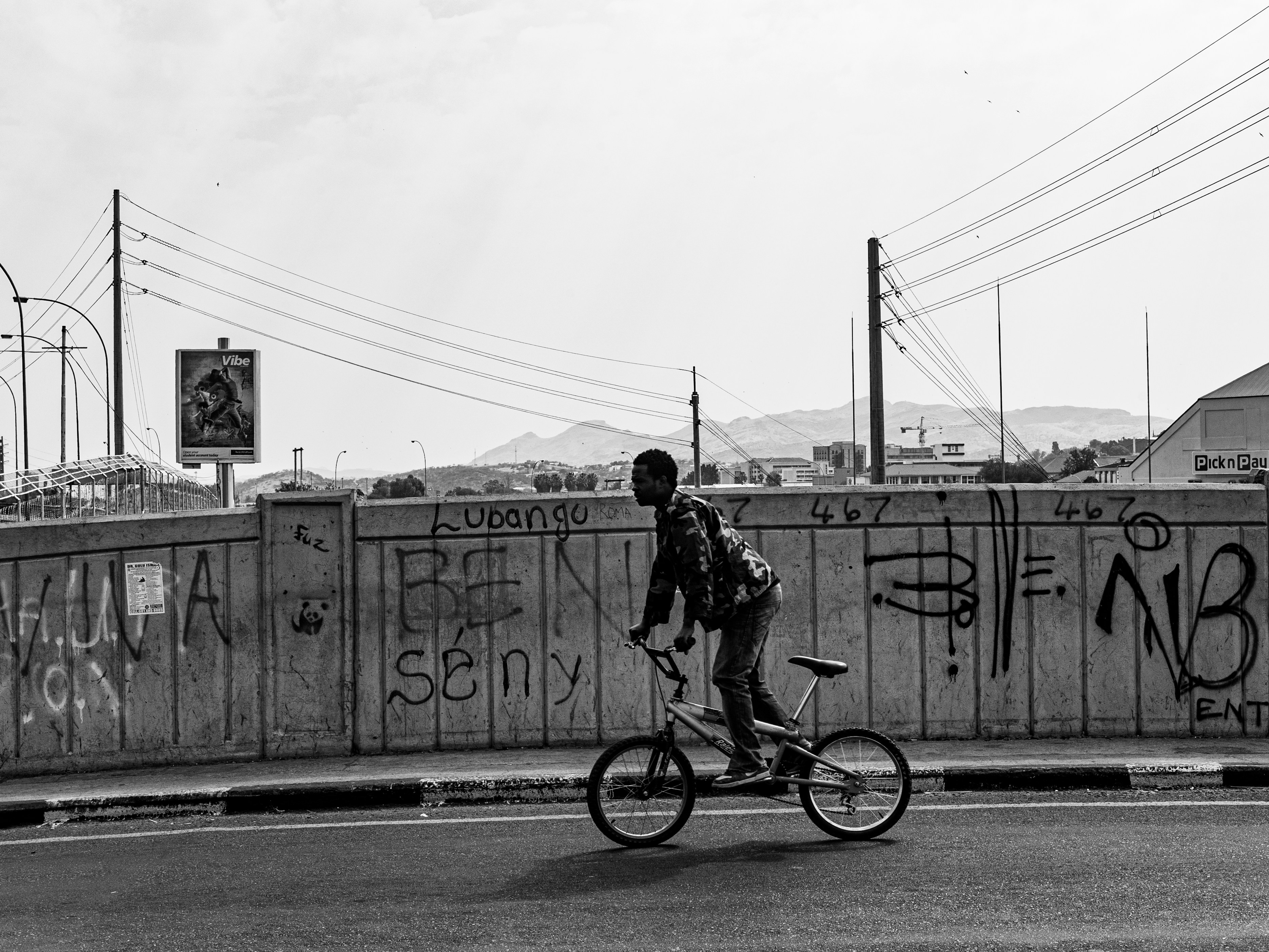 Row of bicycles leaning against a weathered wall