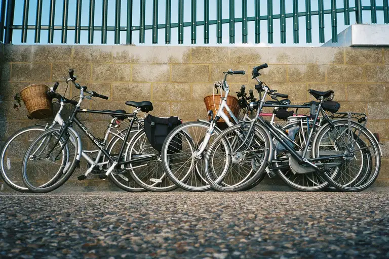 Row of bicycles leaning against a weathered wall