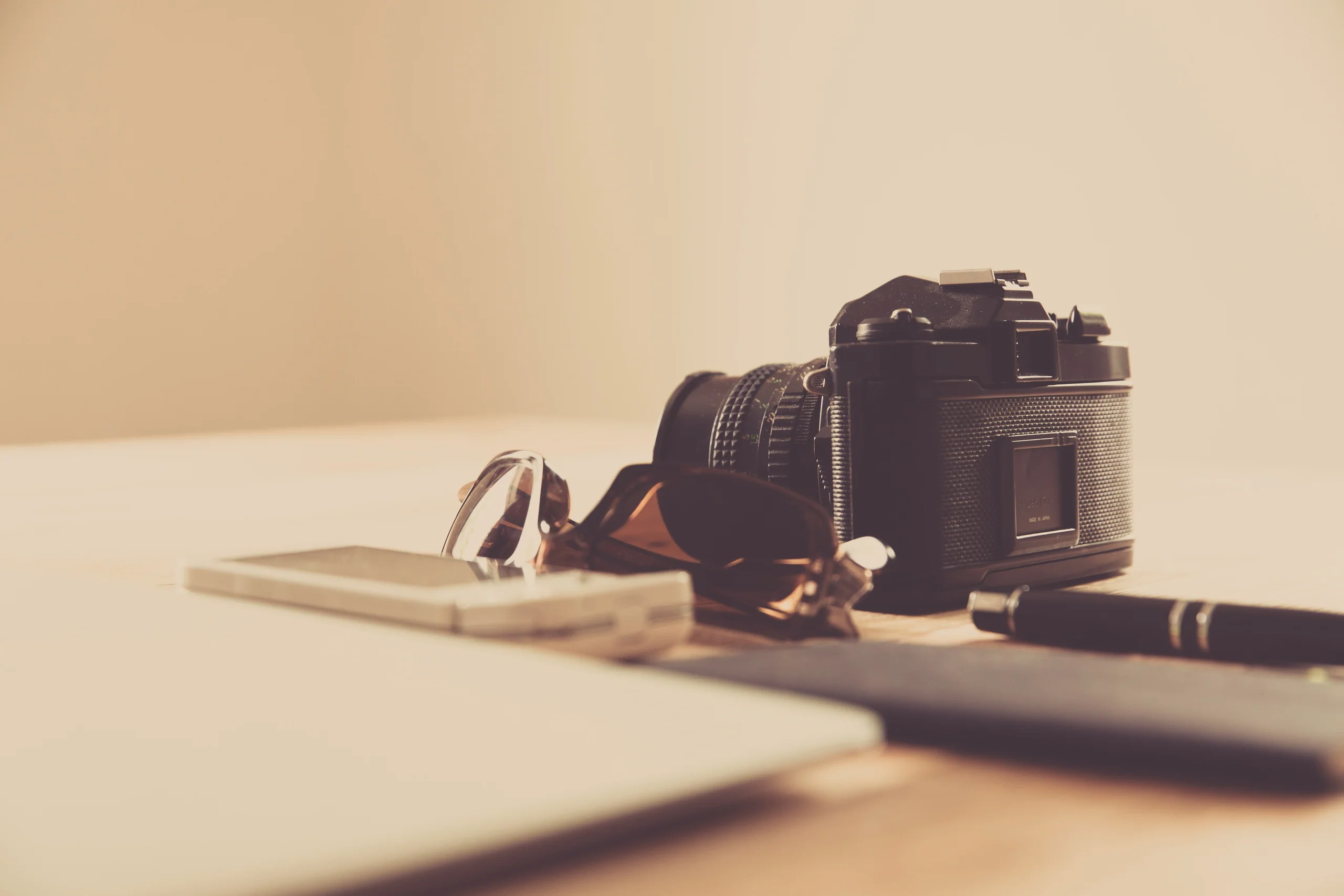 Camera resting on a wooden table in warm window light