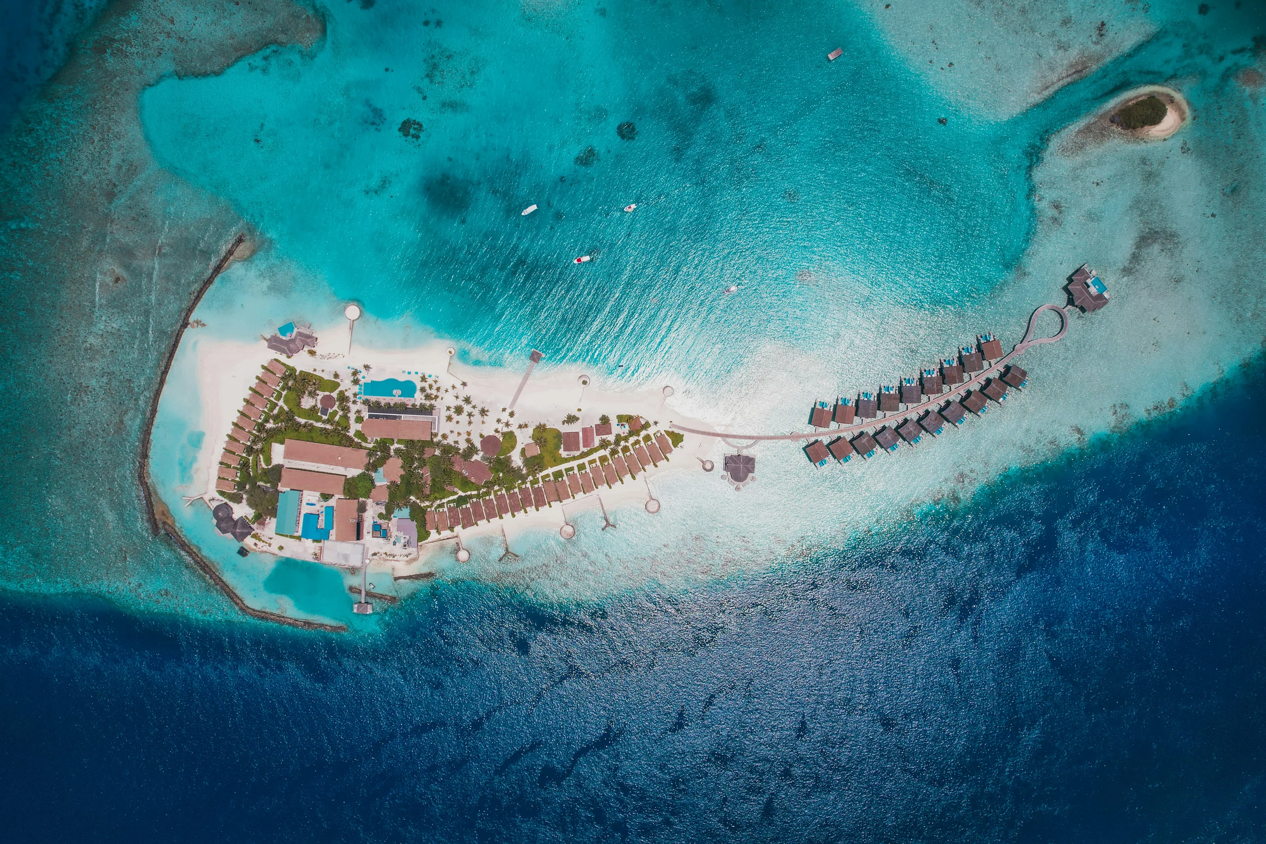 Aerial view of a small island resort ringed by turquoise water